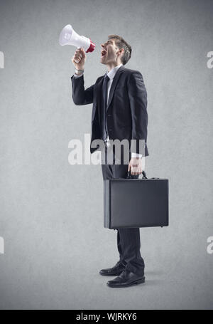 Ein junger Geschäftsmann schreien über Megaphon Stockfoto