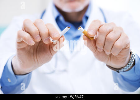 Leitender Arzt bricht eine Zigarette, Stop-Smoking-Konzept. Stockfoto