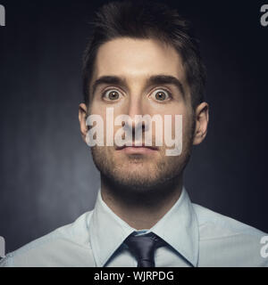 Elegante Jüngling Blick in die Kamera, die Überraschung zum Ausdruck zu bringen. Stockfoto