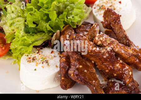 gegrilltes Rindfleisch Streifen frischen gemischten Salat und warmen Ziegenkäse Stockfoto