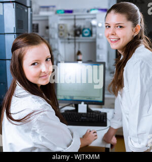 Zwei Chemiestudenten, die Durchführung von Experimenten im Labor (flachen DOF; getönten Farbbild) Stockfoto