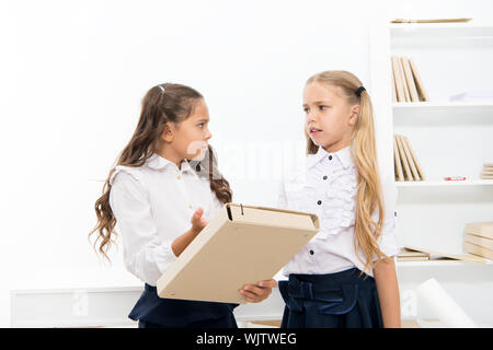 Benötigen Hilfe bei den Hausaufgaben. Adorable kleine Kinder holding Datei mit Hausaufgaben im Unterricht. Hausaufgaben Zuordnung. Zu viel Hausaufgaben ist schlecht für Kinder. Stockfoto