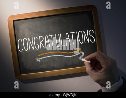 Hand schreiben das Wort herzlichen Glückwunsch zum schwarzen Tafel Stockfoto