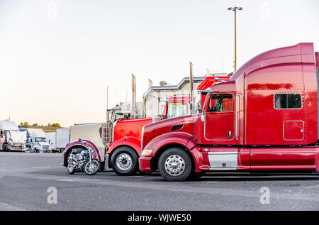 Anders machen und Modelle big Rigs halb Lkw mit Auflieger in Reihe stehen auf Truck Stop Parkplatz für Rest und mit der Bewegung acco entsprechen Stockfoto