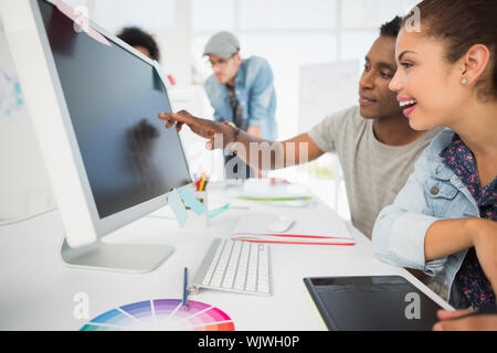 Seitenansicht des beiläufigen Foto Editoren mit Grafiktablett im Büro Stockfoto