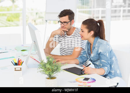 Seitenansicht des beiläufigen Foto Editoren mit Grafiktablett im Büro Stockfoto