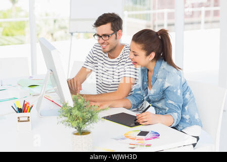 Seitenansicht des beiläufigen Foto Editoren mit Grafiktablett im Büro Stockfoto