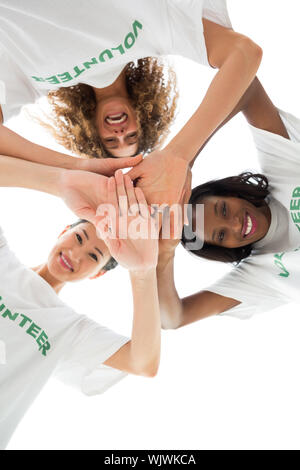 Team von Happy freiwillige Hände zusammen setzen und nach unten an der Kamera auf weißem Hintergrund Stockfoto