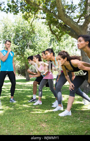 Trainer pfeifen während Marathonläufer bereit zu rennen im Park Stockfoto