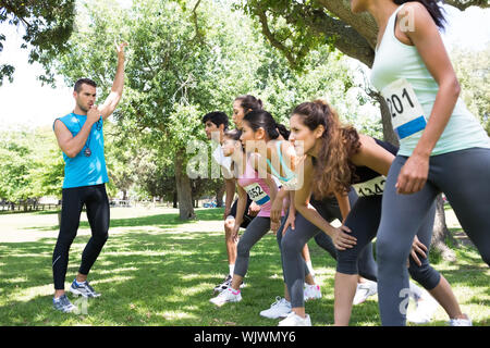 Trainer pfeifen während Marathonläufer bereit zu rennen im Park Stockfoto