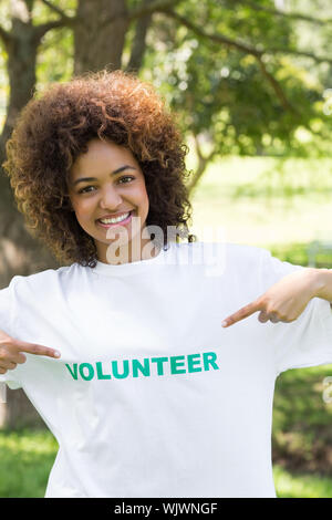 Portrait von zuversichtlich Umweltschützer zeigen auf freiwilliger Tshirt in Park Stockfoto