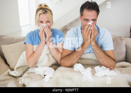 Paare leiden unter Kälte, wie sie auf dem Bett zu Hause sitzen Stockfoto