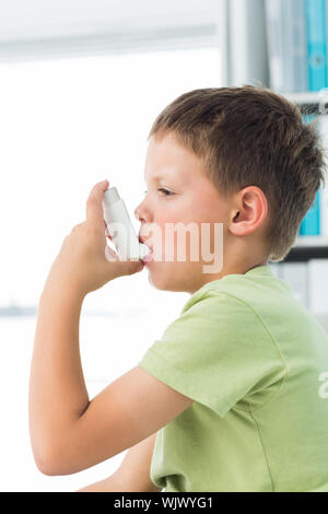 Seitenansicht des kleinen Jungen mit Asthma Inhalator im Krankenhaus Stockfoto