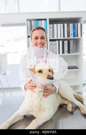 Portrait von weiblichen Tierarzt mit Hund mit medizinischen Kragen in der Klinik Stockfoto