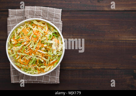 Krautsalat aus frisch geschredderten Weißkohl und geriebenen Karotten in der Schüssel serviert, Overhead mit Kopie Raum fotografiert auf der rechten Seite Stockfoto