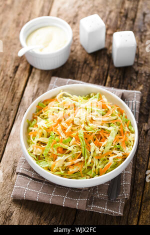 Krautsalat aus frisch geschredderten Weißkohl und geriebenen Karotten in der Schüssel, hausgemachte Mayonnaise- Salat Dressing in der Rückseite (selektive Fokus) Stockfoto