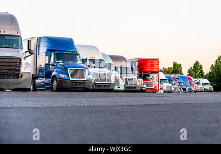 Anders machen und Modelle big Rigs halb Lkw mit Auflieger in Reihe stehen auf Truck Stop Parkplatz für Rest und mit der Bewegung acco entsprechen Stockfoto