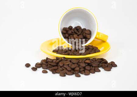 Gelbe Espressotasse mit Kaffeebohnen gefüllt Stockfoto