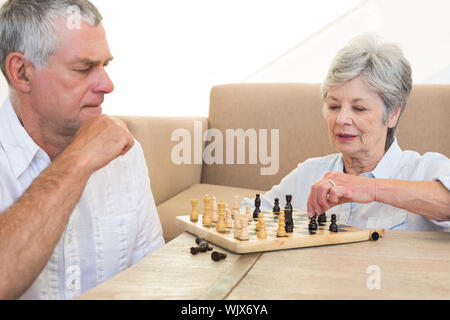 Senior Paar auf, Schach spielen zu Hause sitzen im Wohnzimmer Stockfoto