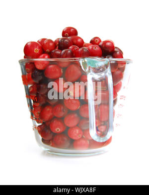 Frische rote Preiselbeeren im Glas Messbecher auf weißem Hintergrund Stockfoto