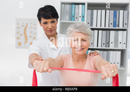 Weiblichen Physiotherapeuten massieren Senior womans zurück in der Arztpraxis Stockfoto