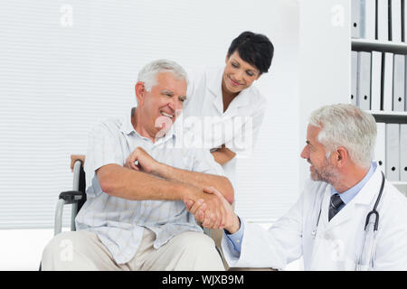 Gerne älterer Patient und Arzt die Hände schütteln in der Arztpraxis Stockfoto