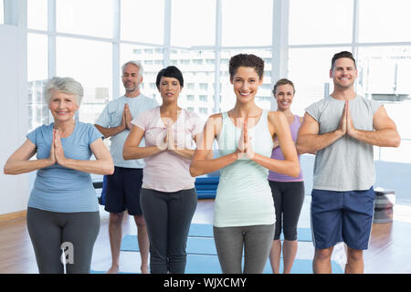 Portrait von sportliche Menschen mit den Händen an einer hellen Fitness Studio verbunden Stockfoto