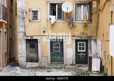 Schöne Aufnahme einer alten gelben Wohnung mit verschiedenen Nummern An den Türen und rissenen Wänden Stockfoto