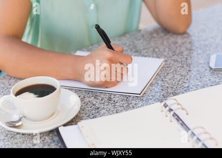 Geschäftsfrau Kaffee und ihre Woche planen in Terrasse des Restaurants Stockfoto