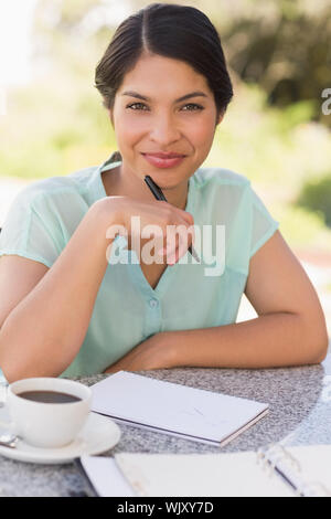 Lächelnd Geschäftsfrau in Kaffee und ihre Woche planen in Terrasse des Restaurants Stockfoto