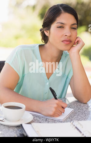 Seriöse Geschäftsfrau Kaffee und ihre Woche planen in Terrasse des Restaurants Stockfoto