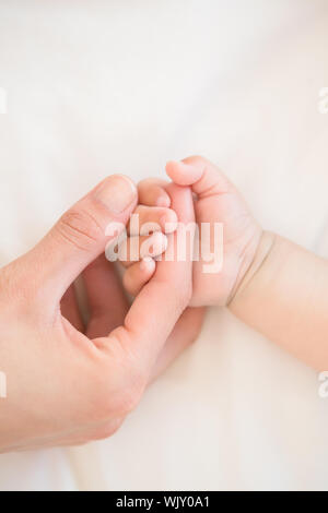 Mutter Holding Baby Kinder zu Hause im Schlafzimmer Stockfoto