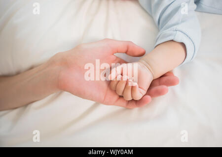 Mutter Holding Baby Kinder zu Hause im Schlafzimmer Stockfoto