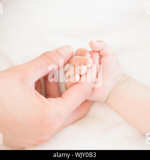 Mutter Holding Baby Kinder zu Hause im Schlafzimmer Stockfoto