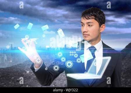 Digital composite asiatischer Geschäftsmann berühren e-Symbole mit Laptop Stockfoto