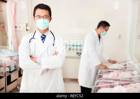 Arzt und Assistent Versorgung Neugeborener Babys im Babyzimmer Stockfoto