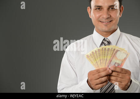 Geschäftsmann zeigt indische Rupien-banknote Stockfoto