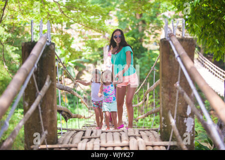 Junge Mutter mit ihrem kleinen Mädchen auf Hängebrücke über den Fluss Loboc, Philippinen Stockfoto