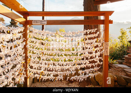 DEC 3, 2018 Yamagata, Japan - Omikuji Japan fortune Papierstreifen Riegel am Seil unter Abendlicht flare an yamadera Tempel. Stockfoto