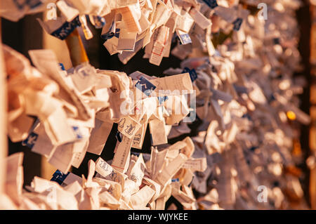 DEC 3, 2018 Yamagata, Japan - Omikuji Japan fortune Papierstreifen Riegel am Seil unter Abendlicht flare an yamadera Tempel. Stockfoto