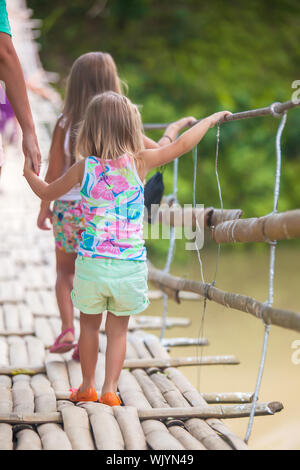 Rückansicht des kleinen Mädchen zu Fuß auf der Hängebrücke über den Fluss Loboc, Philippinen Stockfoto