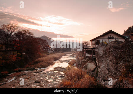 DEC 3, 2018 Yamagata, Japan - alte japanische Haus auf Fels Felsen durch Tachiya Fluss mit Sonnenuntergang am Abend Licht und warmen Ton Himmel im späten Herbst Stockfoto