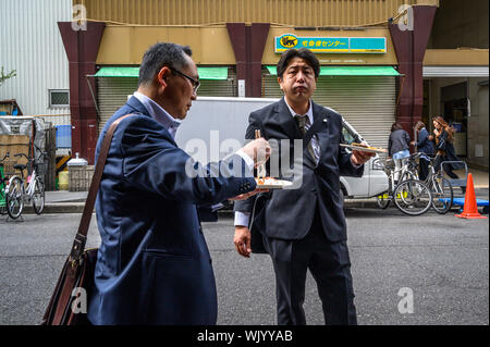 Japanische salarymen Essen von einem Essen in Tsukiji äußeren Markt, Tokio, Japan Abschaltdruck Stockfoto
