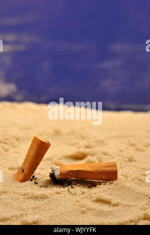 einige Zigarettenstummel am Sandstrand Stockfoto