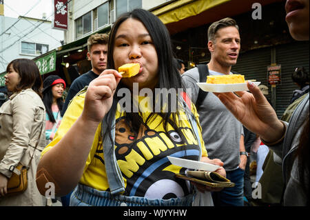 Touristen essen von einem Essen in Tsukiji äußeren Markt, Tokio, Japan Abschaltdruck Stockfoto