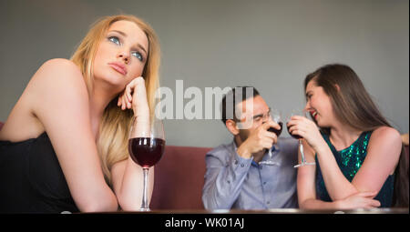 Blonde Frau Gefühl zweier Menschen eifersüchtig sind neben ihr flirten Stockfoto