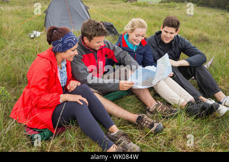 Freunde sitzen Blick auf Karte auf camping-Ausflug Stockfoto
