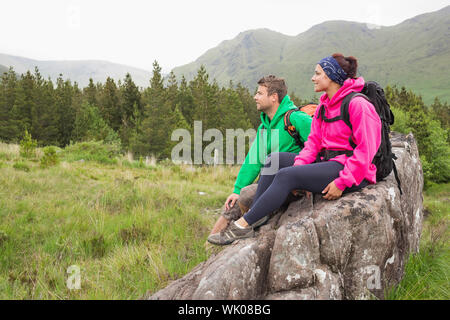 Paar sitzt auf einem Felsen bewundern die Landschaft Stockfoto