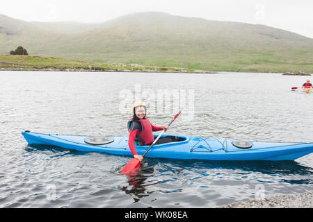 Lächelnde Frau in einem Kajak Stockfoto
