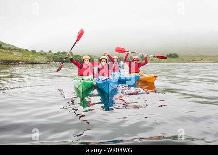 Freunde passen auf einem See rudern Stockfoto